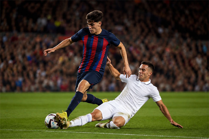 A soccer player going into a sliding tackle