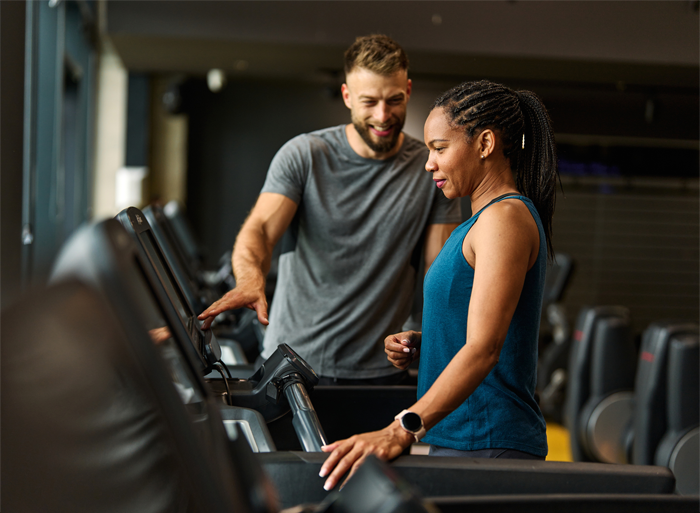 A coach helping an athlete on a treadmill